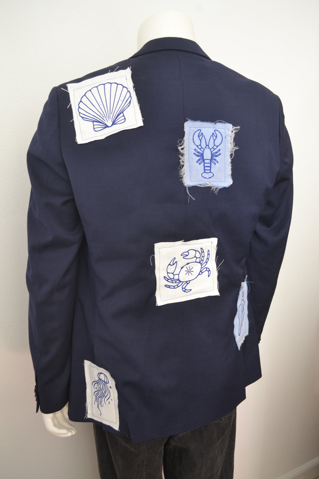 Marinblå blazer bagfra med broderede havmotiver