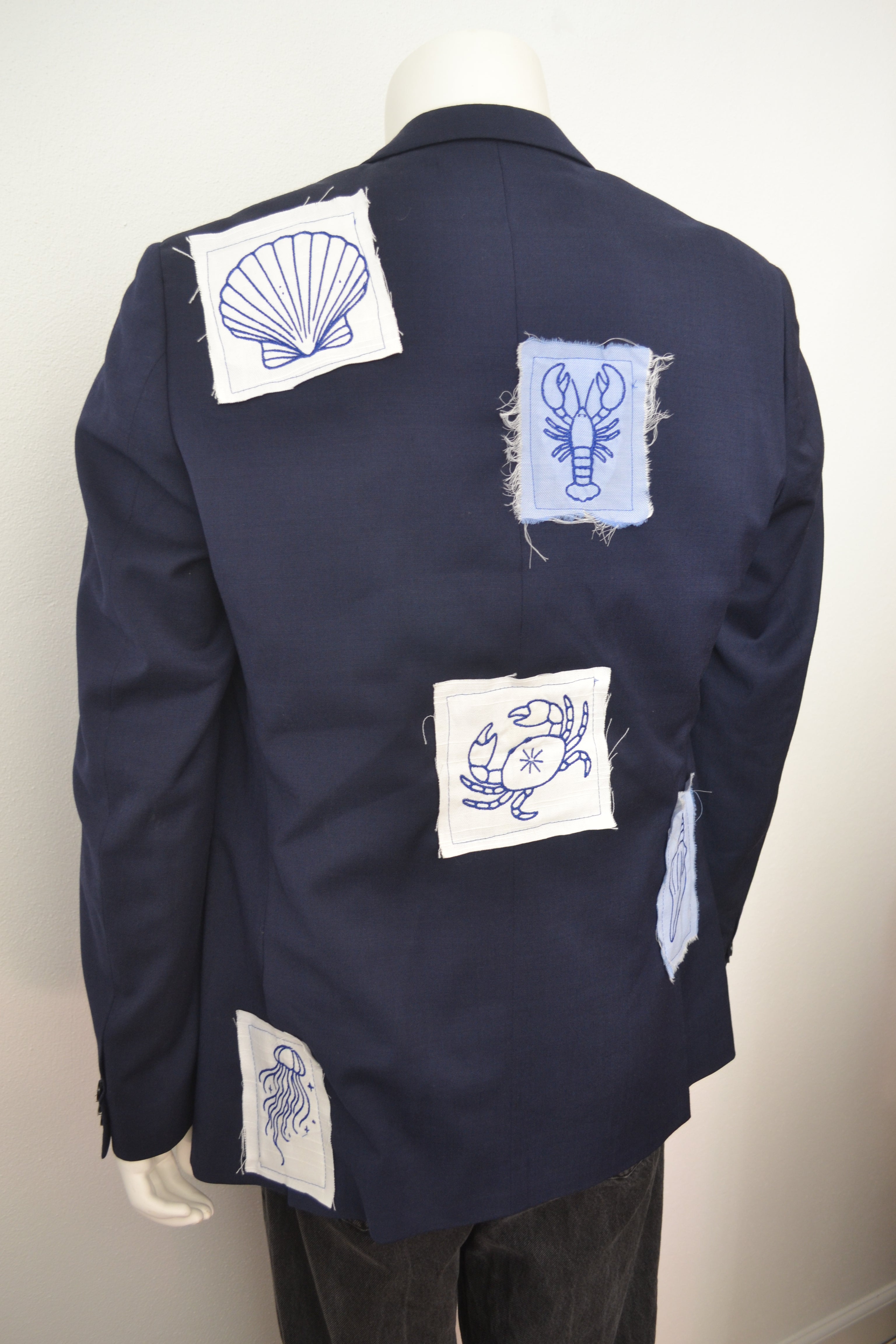 Marinblå blazer bagfra med broderede havmotiver