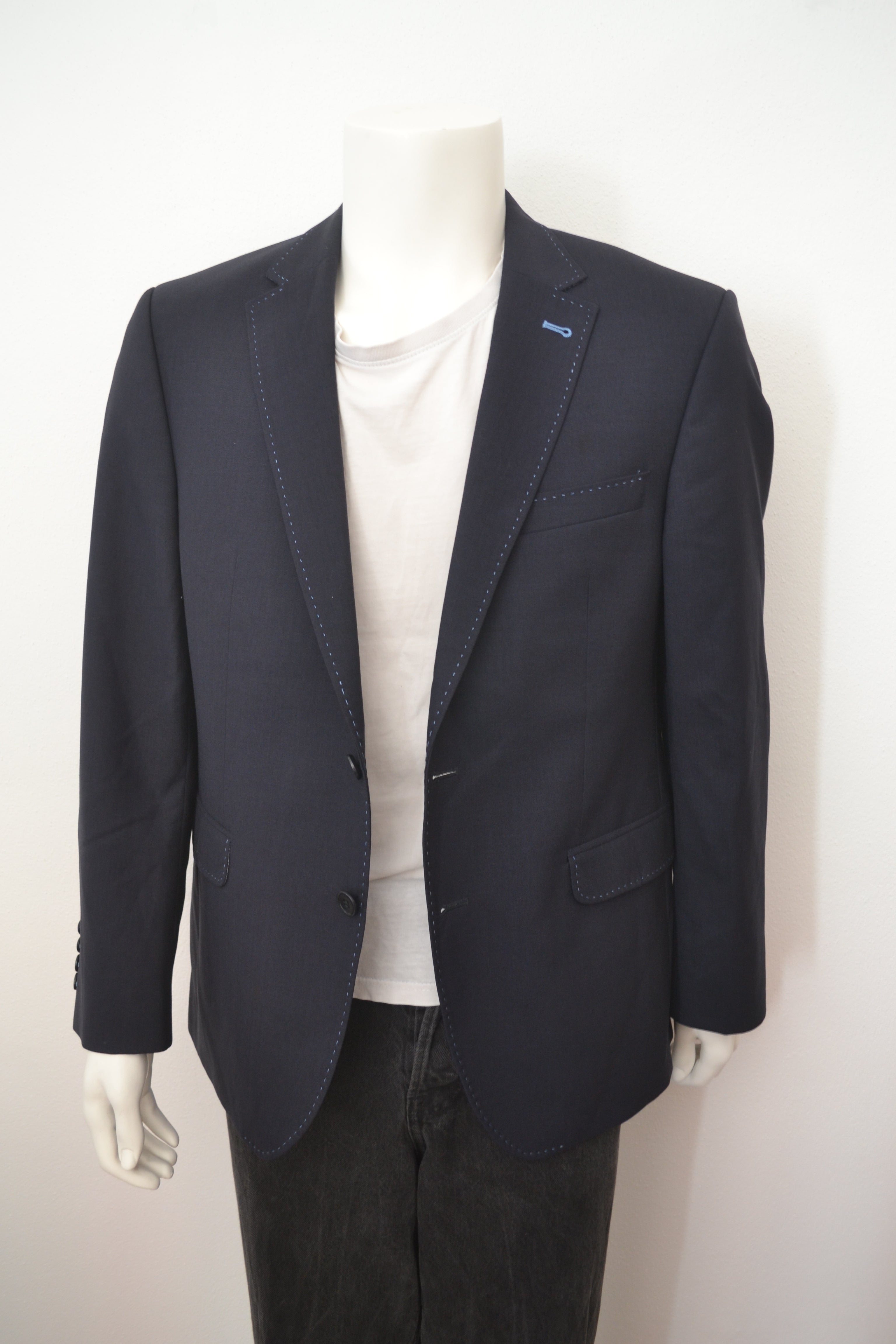 Sort blazer forfra med lyseblå patches