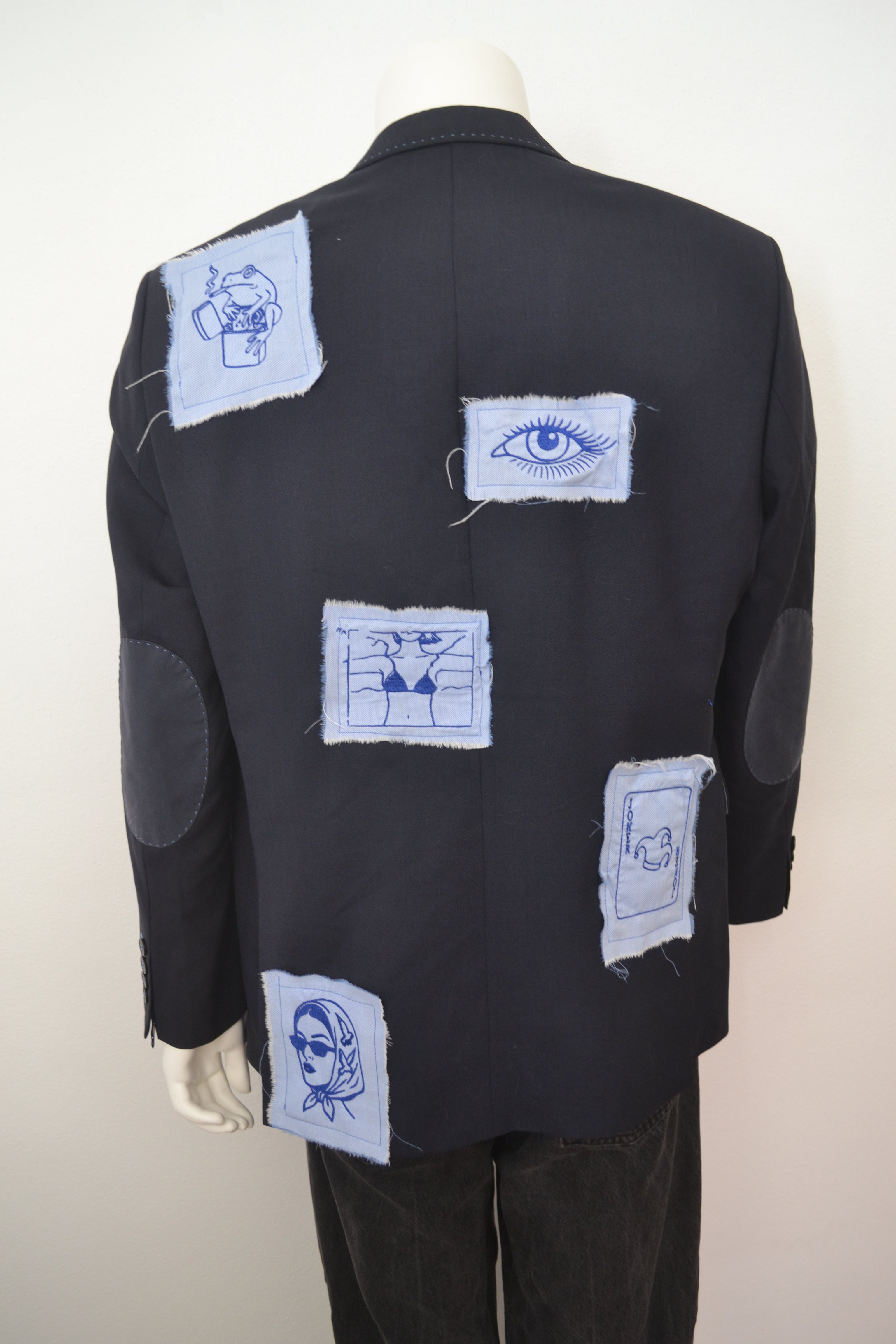 Sort blazer bagfra med broderede motiver på lyseblå patches