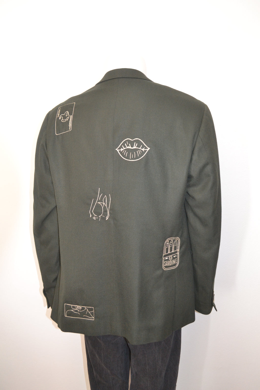 Mørkegrøn blazer bagfra med cremefarvede broderede motiver