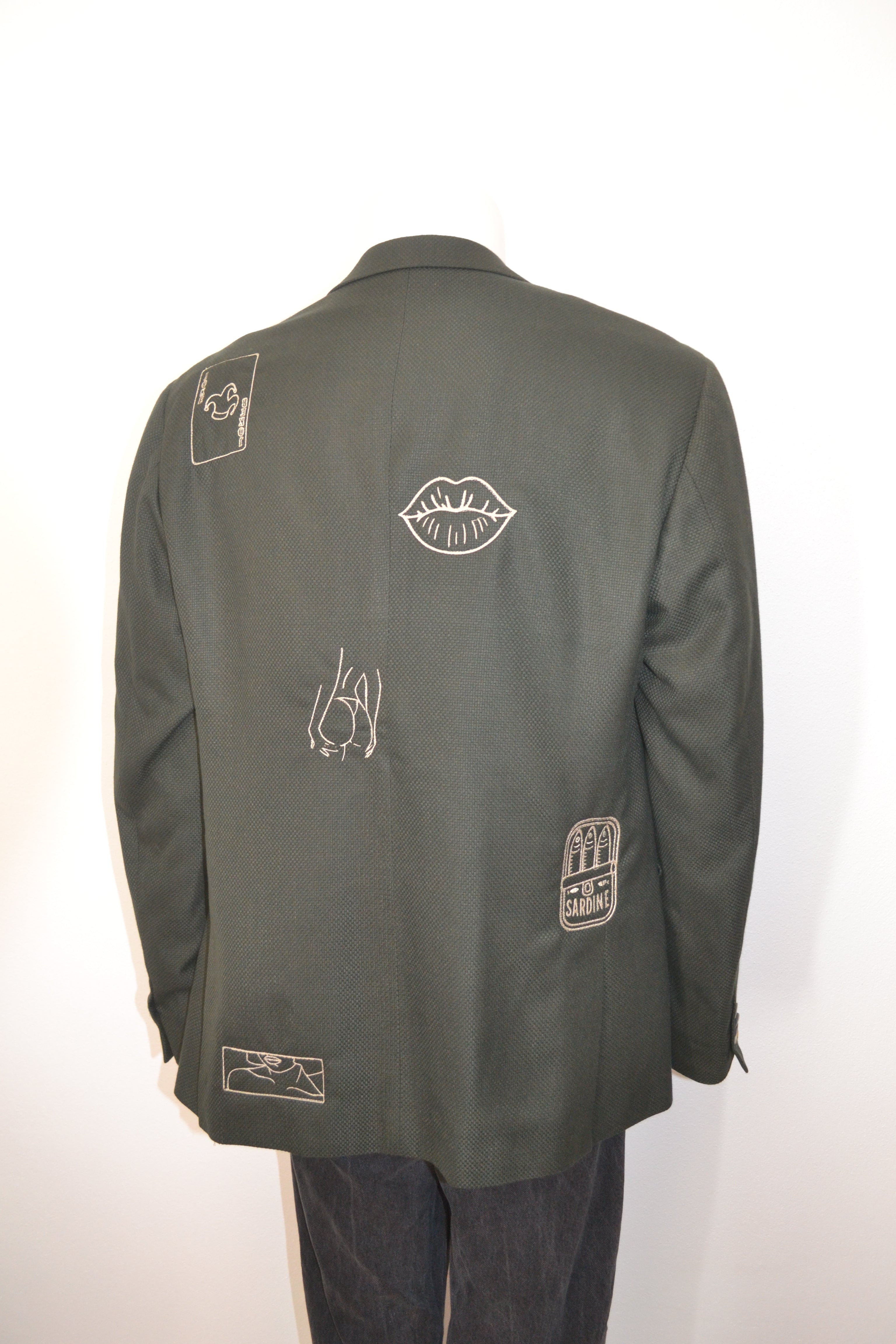 Mørkegrøn blazer bagfra med cremefarvede broderede motiver